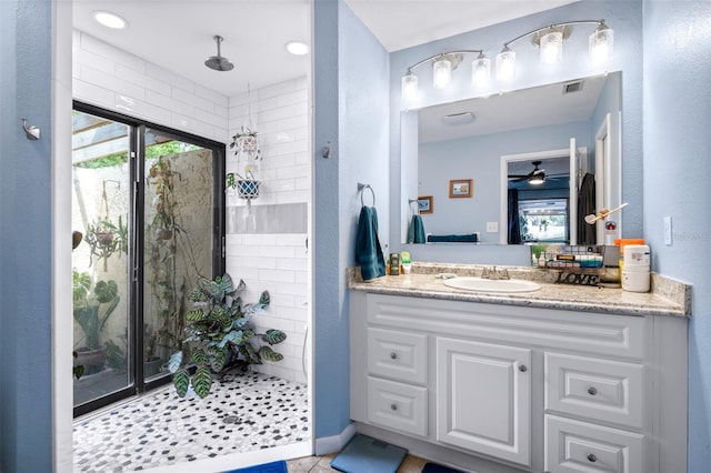 full bath with vanity, ceiling fan, a stall shower, and visible vents
