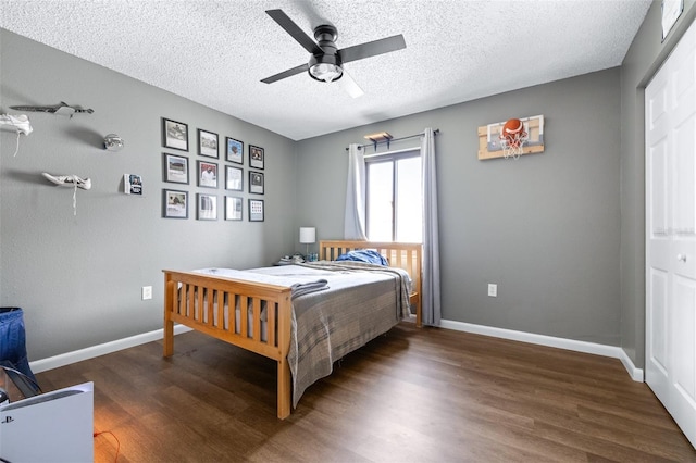 bedroom featuring baseboards, a ceiling fan, a textured ceiling, and wood finished floors