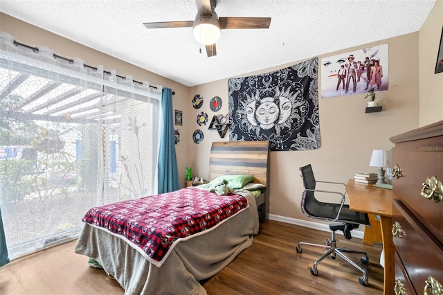 bedroom featuring baseboards, a ceiling fan, a textured ceiling, and wood finished floors