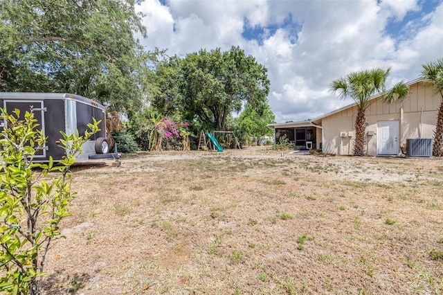 view of yard with a playground and central AC