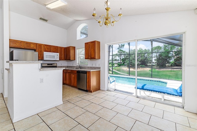 2660 Hemingway Ave, Haines City, FL 33844 - kitchen featuring brown cabinetry, visible vents, an inviting chandelier, light countertops, and appliances with stainless steel finishes