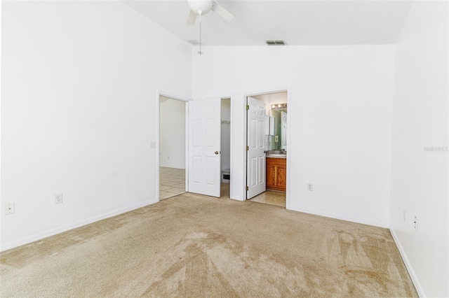 2660 Hemingway Ave, Haines City, FL 33844 - unfurnished bedroom with connected bathroom, visible vents, baseboards, light colored carpet, and lofted ceiling