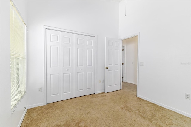 2660 Hemingway Ave, Haines City, FL 33844 - unfurnished bedroom featuring baseboards, carpet flooring, a closet, and a towering ceiling