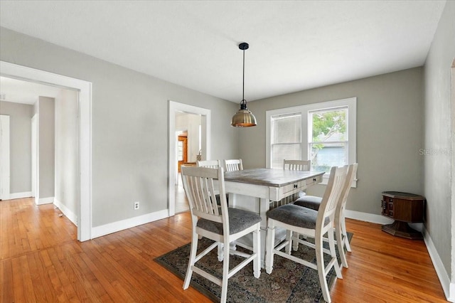 dining room featuring light wood finished floors and baseboards