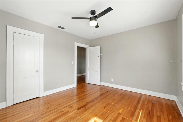 unfurnished bedroom featuring light wood-type flooring, visible vents, baseboards, and a ceiling fan