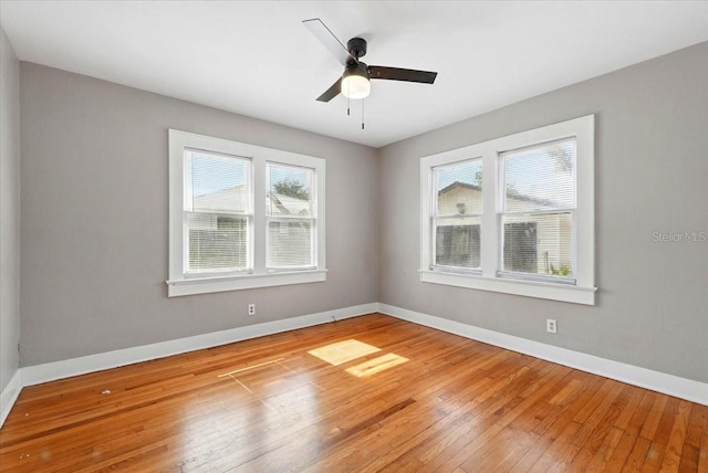 empty room featuring baseboards, light wood-style flooring, and ceiling fan