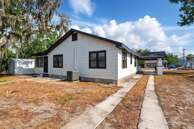 view of property exterior featuring central AC, a shed, an outdoor structure, and crawl space
