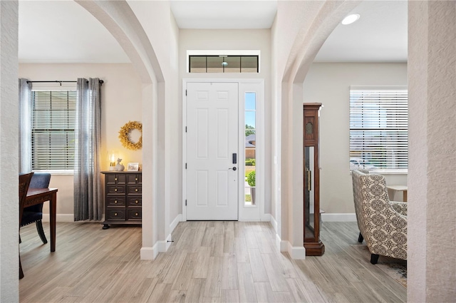 5531 Pebble Beach Dr, Lakeland, FL 33812 - entrance foyer with arched walkways, baseboards, and wood finished floors