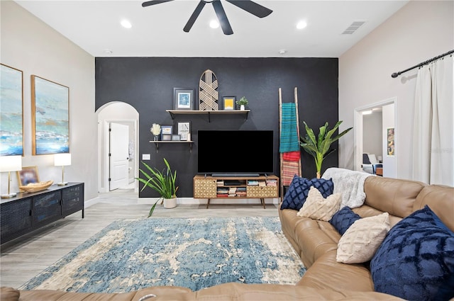 5531 Pebble Beach Dr, Lakeland, FL 33812 - living room with visible vents, an accent wall, wood finished floors, ceiling fan, and arched walkways