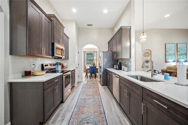 5531 Pebble Beach Dr, Lakeland, FL 33812 - kitchen with arched walkways, appliances with stainless steel finishes, a sink, and dark brown cabinets