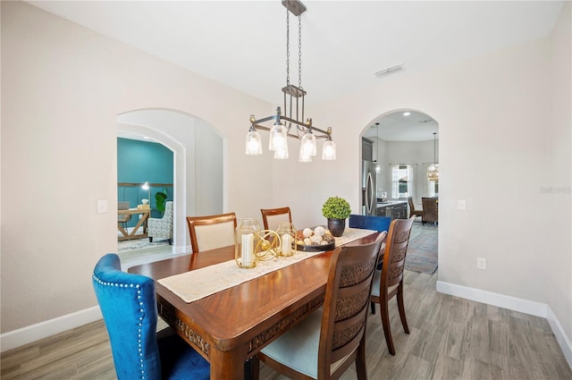 5531 Pebble Beach Dr, Lakeland, FL 33812 - dining room with visible vents, arched walkways, light wood finished floors, and baseboards