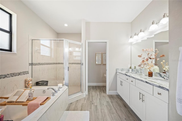 5531 Pebble Beach Dr, Lakeland, FL 33812 - full bath featuring a sink, double vanity, wood finished floors, a bath, and a stall shower
