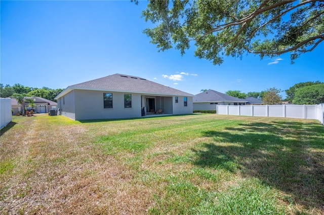 5531 Pebble Beach Dr, Lakeland, FL 33812 - rear view of property featuring fence, stucco siding, a lawn, and roof with shingles