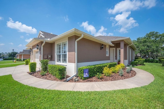 2965 Mission Lakes Dr, Lakeland, FL 33803 - view of property exterior featuring a lawn, a garage, stucco siding, and driveway