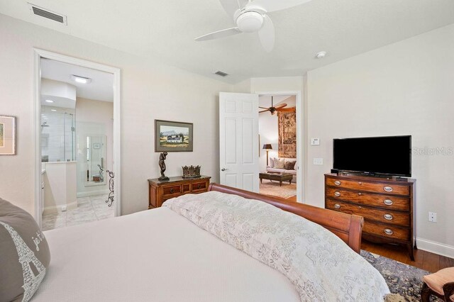 2965 Mission Lakes Dr, Lakeland, FL 33803 - bedroom featuring ceiling fan, ensuite bathroom, baseboards, and wood finished floors