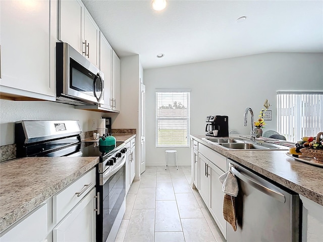 kitchen with light tile patterned flooring, a sink, stainless steel appliances, recessed lighting, and white cabinetry