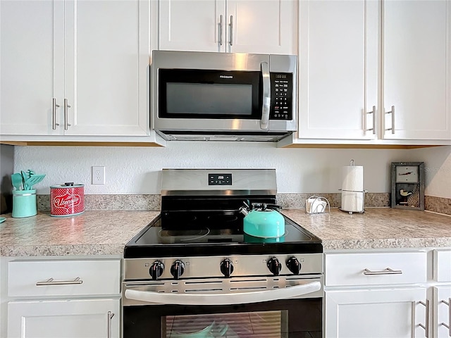 kitchen with light countertops, appliances with stainless steel finishes, and white cabinets
