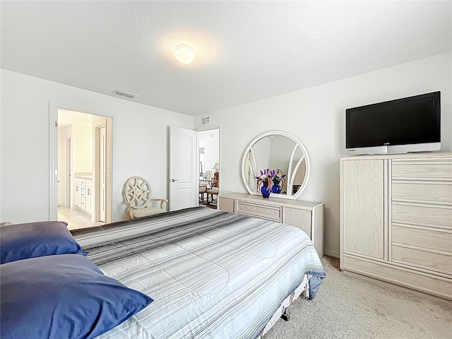 bedroom featuring light carpet, connected bathroom, and visible vents