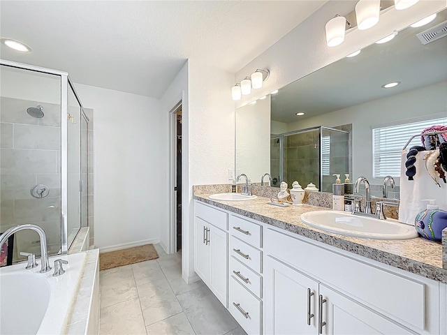 bathroom featuring double vanity, visible vents, a sink, and a stall shower