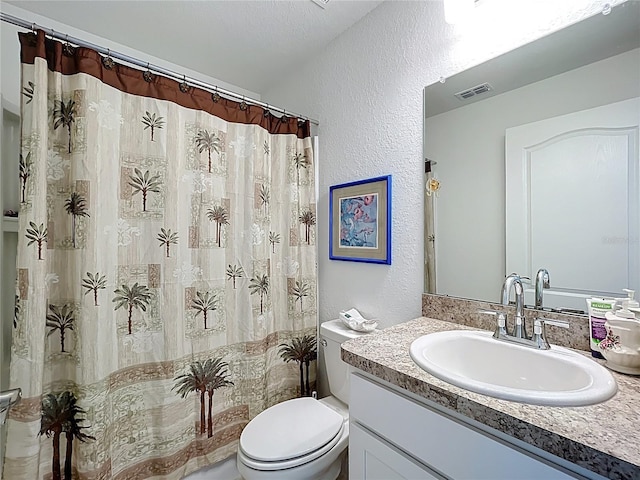 bathroom with toilet, a textured wall, visible vents, and vanity