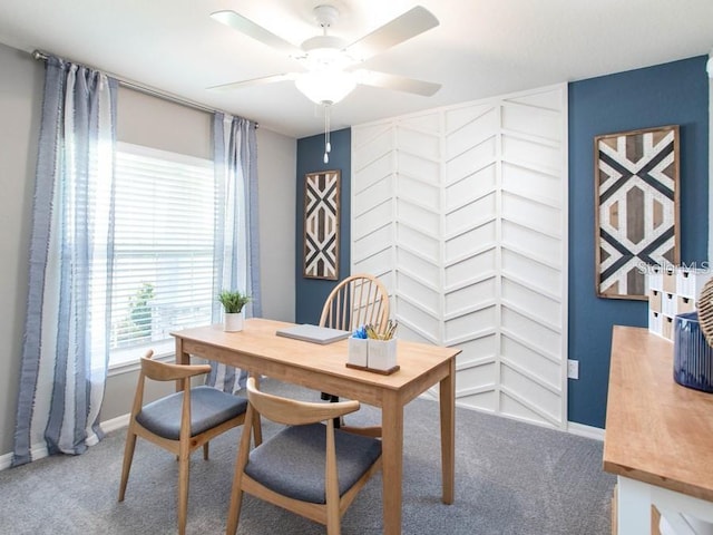 carpeted office with baseboards and a ceiling fan