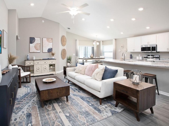 living room with recessed lighting, a ceiling fan, wood finished floors, and vaulted ceiling