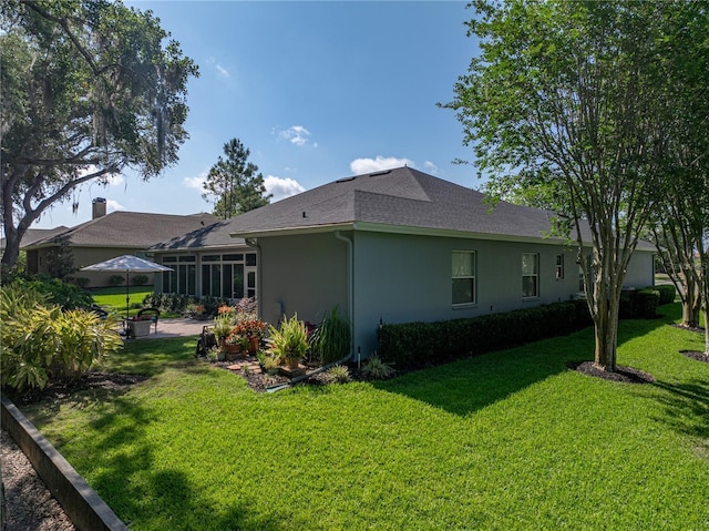 800 Osprey Landing Dr, Lakeland, FL 33813 - back of property featuring a lawn, stucco siding, a sunroom, and a shingled roof
