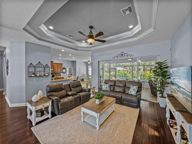 800 Osprey Landing Dr, Lakeland, FL 33813 - living room featuring a raised ceiling, a ceiling fan, crown molding, dark wood-style flooring, and baseboards