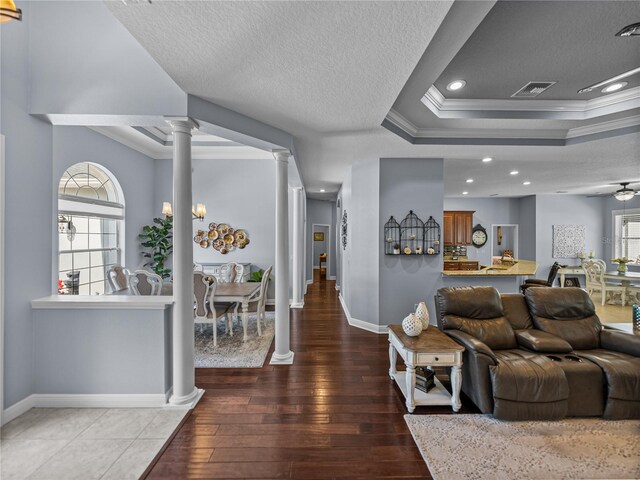 800 Osprey Landing Dr, Lakeland, FL 33813 - living area featuring ornate columns, crown molding, a textured ceiling, baseboards, and hardwood / wood-style flooring