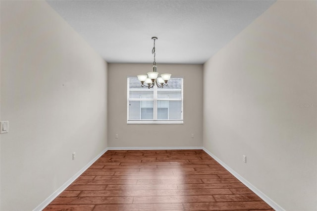 3592 Prescott Loop, Lakeland, FL 33810 - spare room with wood-type flooring, baseboards, and a notable chandelier