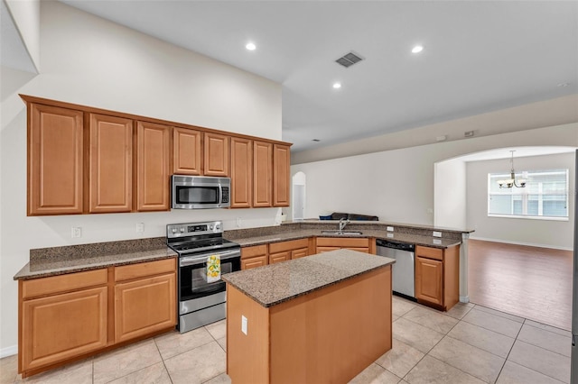 3592 Prescott Loop, Lakeland, FL 33810 - kitchen featuring appliances with stainless steel finishes, arched walkways, a sink, a peninsula, and a chandelier
