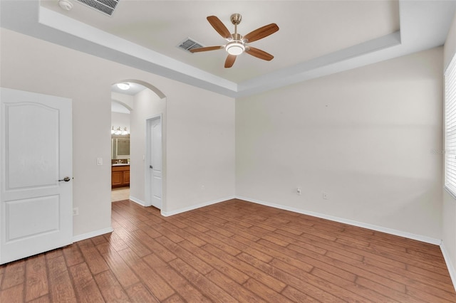 3592 Prescott Loop, Lakeland, FL 33810 - spare room featuring ceiling fan, visible vents, arched walkways, a raised ceiling, and wood-type flooring