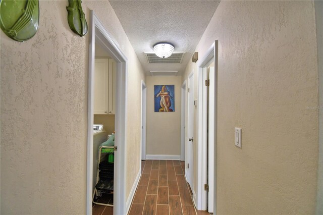hall featuring a textured ceiling and visible vents
