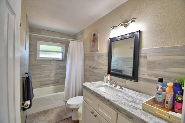 bathroom featuring vanity, shower / tub combo with curtain, wainscoting, and toilet