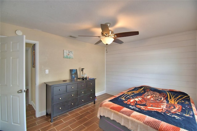 bedroom featuring baseboards, visible vents, ceiling fan, and wood tiled floor