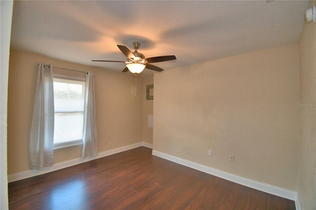unfurnished room with dark wood-type flooring, baseboards, and ceiling fan