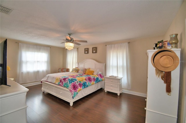 bedroom featuring dark wood-type flooring, visible vents, and multiple windows