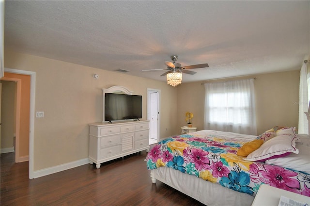 bedroom with a ceiling fan, baseboards, a textured ceiling, and dark wood-type flooring