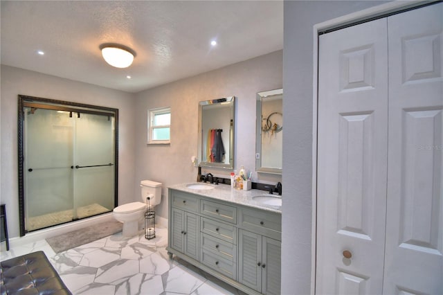 bathroom with double vanity, toilet, a sink, and marble finish floor
