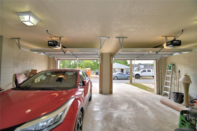 garage with concrete block wall and a garage door opener