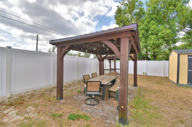 view of yard featuring a storage shed, an outdoor structure, a gazebo, and a fenced backyard