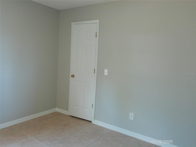 unfurnished room featuring baseboards and light tile patterned flooring