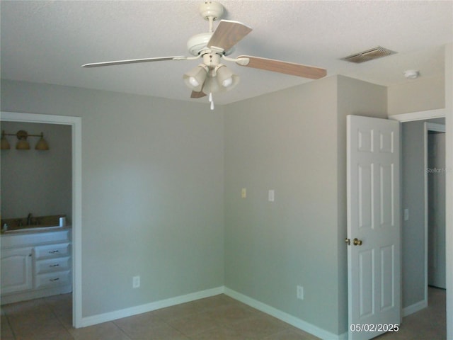 unfurnished bedroom featuring visible vents, a sink, a textured ceiling, and light tile patterned floors