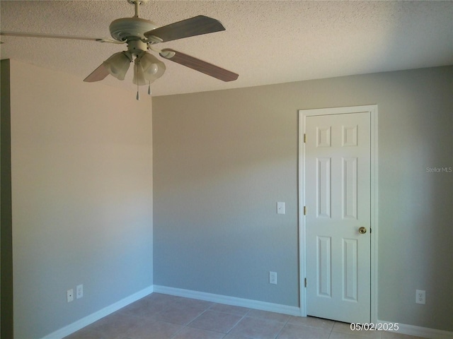 unfurnished room featuring baseboards, a ceiling fan, a textured ceiling, and light tile patterned floors