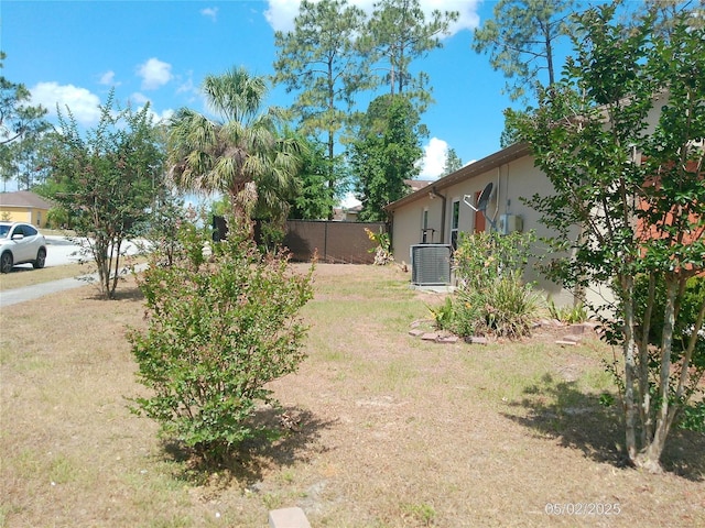 view of yard with fence and central AC