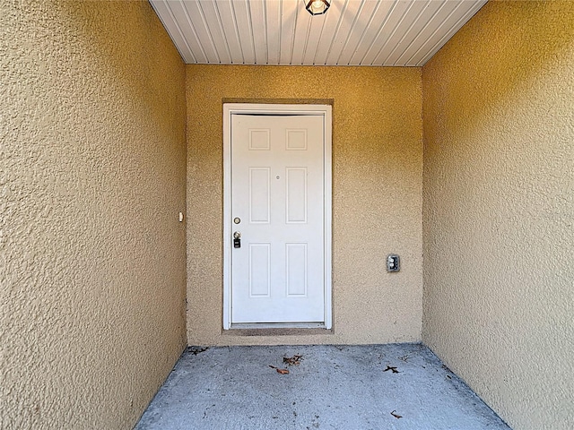 view of exterior entry featuring stucco siding