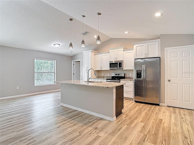 kitchen with appliances with stainless steel finishes, a sink, light wood finished floors, a textured ceiling, and white cabinets