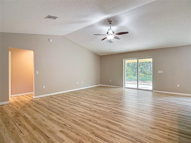 unfurnished living room with ceiling fan, light wood-style floors, a textured ceiling, baseboards, and vaulted ceiling
