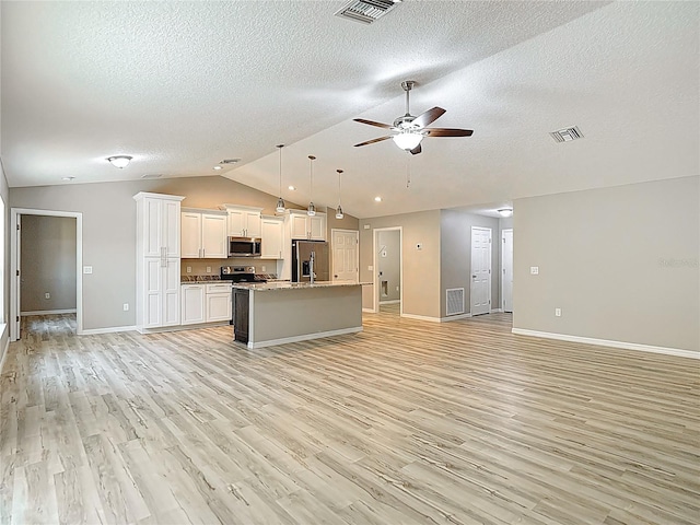 unfurnished living room with vaulted ceiling, a ceiling fan, baseboards, light wood-style floors, and a textured ceiling