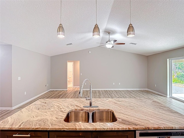 kitchen with a sink, open floor plan, light wood-style floors, a center island with sink, and dishwasher